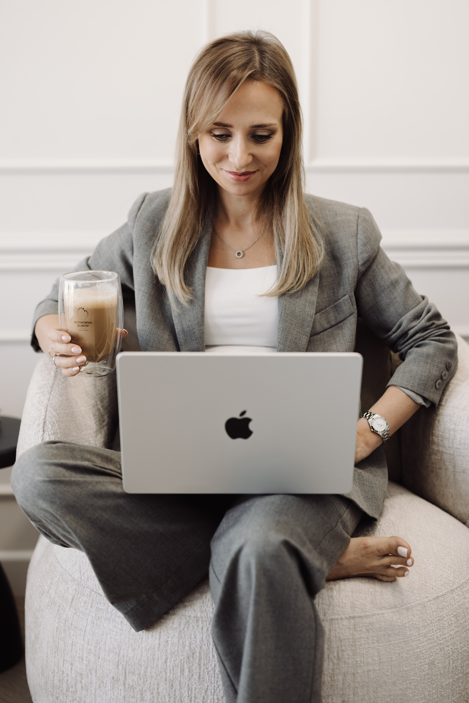 Agnieszka Kudela pracuje przy laptopie w swoim biurze